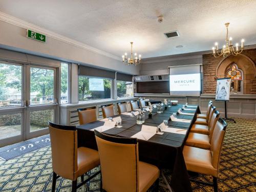 a conference room with a long table and chairs at Mercure Manchester Norton Grange Hotel & Spa in Rochdale