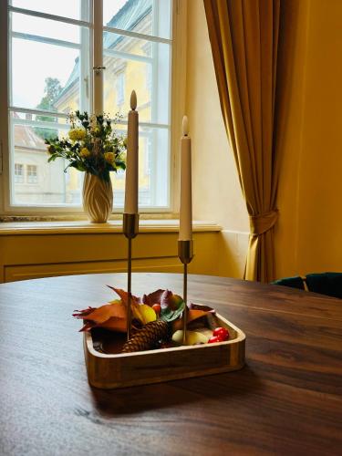 a tray of fruit on a table with three candles at Zámecké Apartmány Marlene in Česká Kamenice