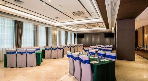 a conference room with tables and chairs in a building at Fuzhou Xin Zi Yang Hotel in Fuzhou