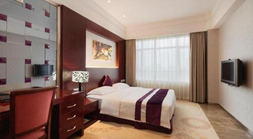 a hotel room with a bed and a television at Fuzhou Xin Zi Yang Hotel in Fuzhou