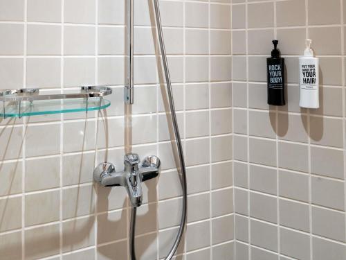 a shower with a hose in a bathroom at Ibis Singapore on Bencoolen - Newly Renovated in Singapore