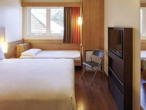 Ένα ή περισσότερα κρεβάτια σε δωμάτιο στο ibis Porto Alegre Moinhos de Vento