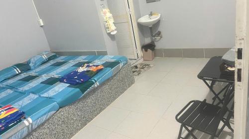 a bedroom with a bed and a table and a sink at Nhà Nghỉ Hiếu Lê in Ngã Ba Lâm Giồ