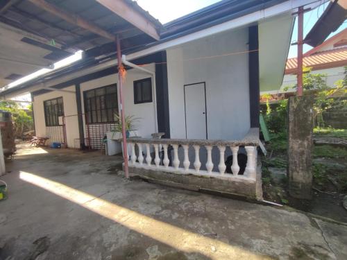 a small white house with a porch and a door at Belle Go in Bauang
