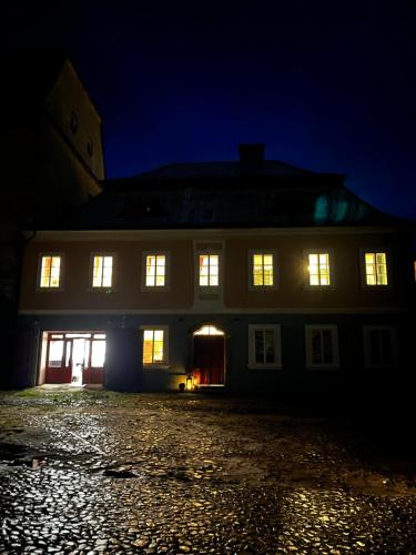 a large white building with lit up windows at night at Zámecké Apartmány Marlene in Česká Kamenice