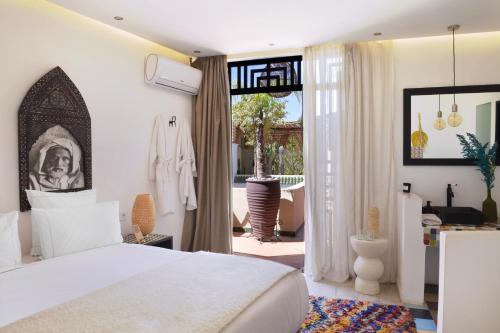 een slaapkamer met een wit bed en een balkon bij Riad Palau Marrakech in Marrakesh