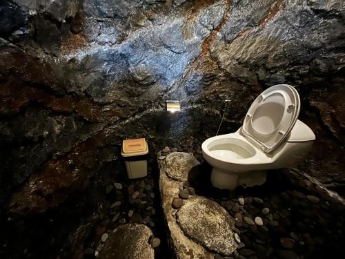 um banheiro com vaso sanitário em uma caverna em Cabin swargana em Tampaksiring
