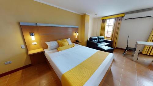 a hotel room with a large bed and a chair at Swiss Chalet in Angeles