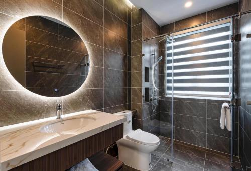 a bathroom with a sink and a toilet and a mirror at Zenda Villa Novaworld Phan Thiết in Bình Tú
