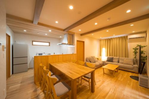 a kitchen and living room with a wooden table at ゆけむりの宿 小町荘 in Beppu