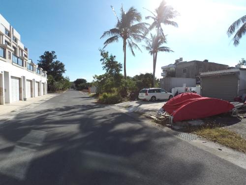 a red tent on the side of a street with palm trees at Have FUN villa in Hengchun