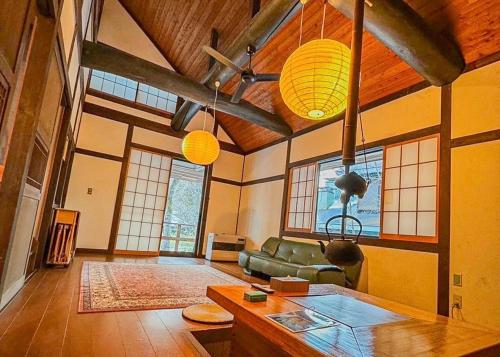 a living room with a green couch and some windows at THE HIDEOUT VILLA KUSATSU - Vacation STAY 90944v in Kusatsu