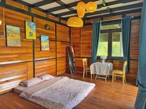 ein Schlafzimmer mit einem Bett und einem Tisch und Stühlen in der Unterkunft Nhà Dưới Đồi Homestay in Ấp Man Ling
