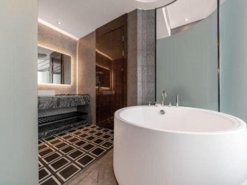 a bathroom with a white tub in a room at Xana Hotelle·Hotel Luzhou Baizitu Square in Luzhou