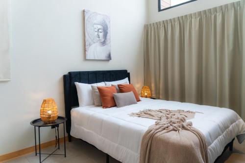 Un dormitorio con una cama grande con almohadas naranjas. en Sakura Haus, en Turrialba