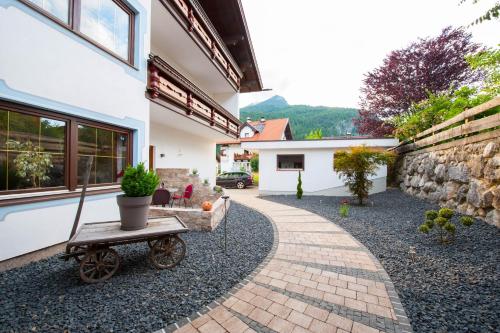 a house with a wheelbarrow in the front yard at Rustika - Appartements & Spa in Ehrwald