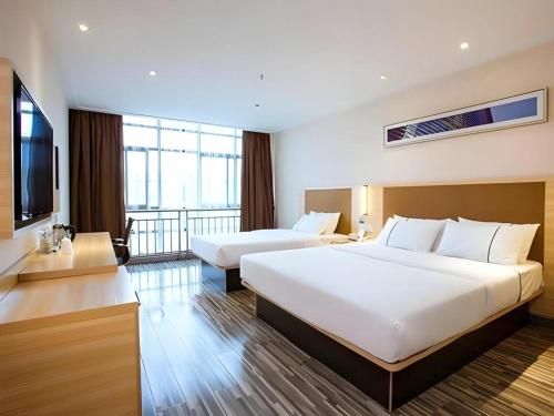 une chambre d'hôtel avec un grand lit et une télévision dans l'établissement City Comfort Inn Guilin North Railway Station, à Guilin