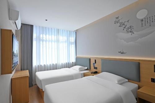 a hotel room with two beds and a tv at Huayi Select Hotel Liujiayao Subway Station Hengliutiao Branch in Beijing