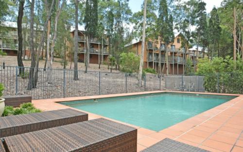 a swimming pool in front of a fence at Private 1bdr Villa Champagne located within Cypress Lakes Resort in Pokolbin