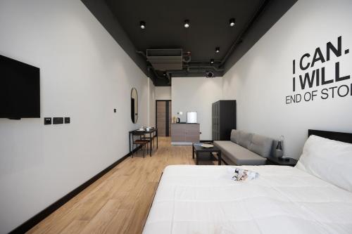 a bedroom with a white bed and a couch at Classic Charm Studio by Spacey in Duqm 89 in Duqm