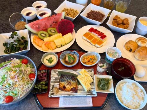 une table recouverte de assiettes et de bols de nourriture dans l'établissement Lit Hotel NAKIJIN, à Nakijin