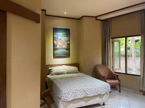 a bedroom with a bed and a picture on the wall at Athaya Beachside Villa in Kadujulang