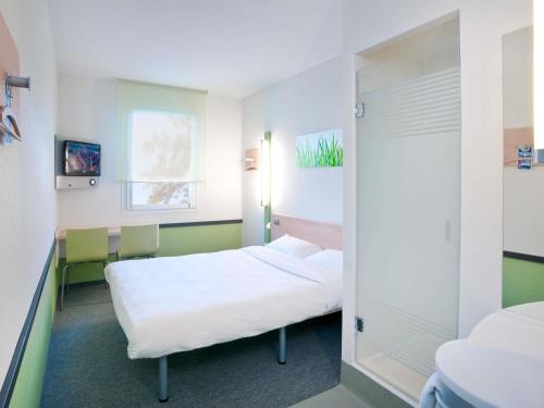 a hospital room with two beds and a mirror at ibis budget Torun in Toruń