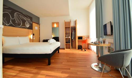 a hotel room with a bed and a desk at ibis Edinburgh Centre South Bridge – Royal Mile in Edinburgh
