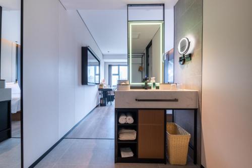 広州市にあるAtour Hotel Guangzhou Zhujiang New Town Taikoo Huiの洗面台と鏡のあるバスルーム