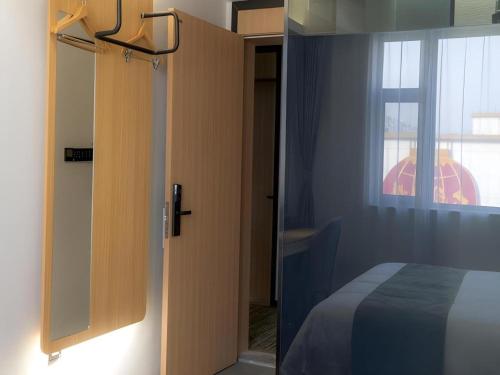 a door to a bedroom with a bed and a window at GreenTree Inn Express Datong High-Speed Railway Station Old City Wall in Datong