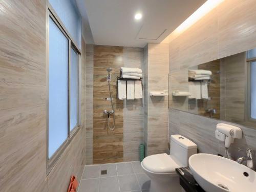 Un baño con inodoro, lavabo y ducha. en Xiaobeilou Inn Zhangjiajie Railway Station Tianmen Mountain Cableway Branch, en Zhangjiajie