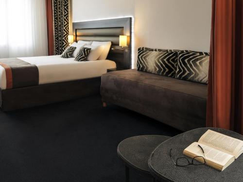 a hotel room with a bed and a table with a book at Mercure Lyon Centre - Gare Part Dieu in Lyon