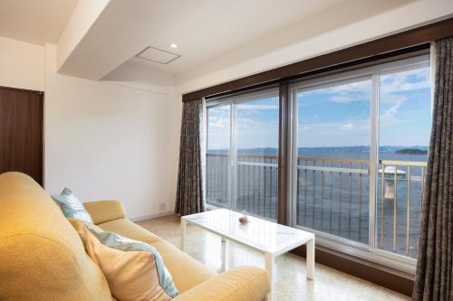 Una sala de estar con un sofá y una ventana grande. en Ocean Smile, 