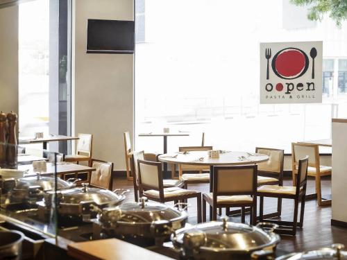 a dining room with tables and chairs and a window at Ibis Singapore Novena in Singapore