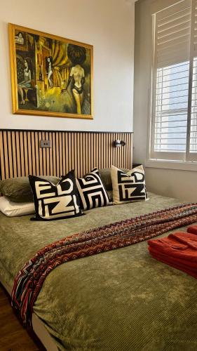 a bedroom with a large bed with pillows on it at Heart of Sydney CBD Chic One Bedroom Apartment with Pool on Bridge Street in Sydney