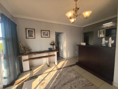 a living room with a table and a window at Harmonie in Hartenbos in Mossel Bay