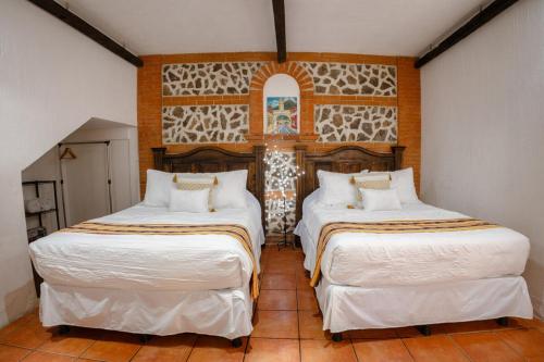 two beds in a room with white sheets at Colonial House 8 rooms and private parking in Antigua Guatemala in Antigua Guatemala