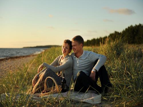 a man and a woman sitting on the beach at Roosta Holiday Village in Elbiku
