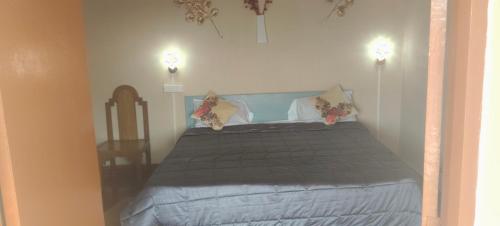 a bedroom with a bed with two lights on the wall at VHP luxury cottage kodaikkanal in Kodaikānāl