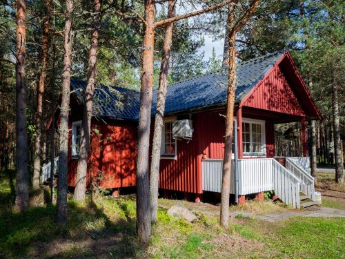 a red cabin in the woods with trees at Roosta Holiday Village in Elbiku