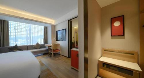 a hotel room with a bed and a living room at Echeng Hotel Nanning the Mixc Convention in Nanning