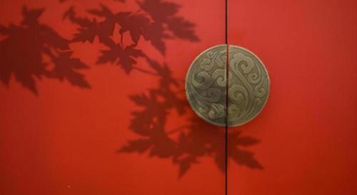 a coin is on the side of a red wall at Echeng Hotel Nanning the Mixc Convention in Nanning
