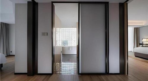 a room with sliding glass doors in a bedroom at Echeng Hotel Nanning the Mixc Convention in Nanning