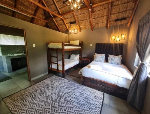 a bedroom with two beds and a bunk bed at Bradbury Game Lodge and Function Venue in Polokwane