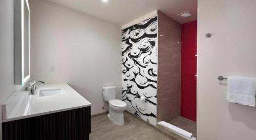 a bathroom with a toilet and a sink and a shower at Ahern Hotel and Event Center in Las Vegas