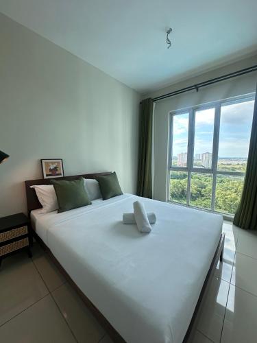 a large white bed in a room with a large window at Metropol by BRB in Bukit Mertajam