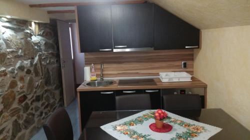 - une petite cuisine avec une table et une composition florale dans l'établissement Apartment Borovnica Rogla, à Resnik