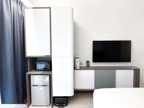 a living room with a tv and a white cabinet at Ibis Hong Kong Central & Sheung Wan in Hong Kong