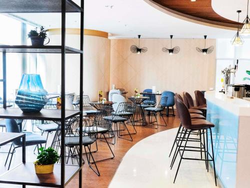 a restaurant with tables and chairs in a room at Ibis Hong Kong Central & Sheung Wan in Hong Kong