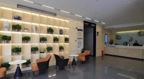 a lobby with a waiting area with chairs and plants at GreenTree Inn Express Fuyang University Town West High-Speed Railway Station in Fuyang